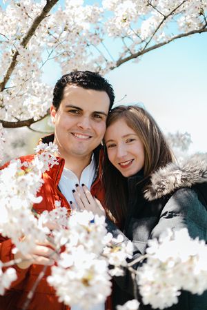Close-up romantic portraits framed by delicate white cherry blossoms in spring.