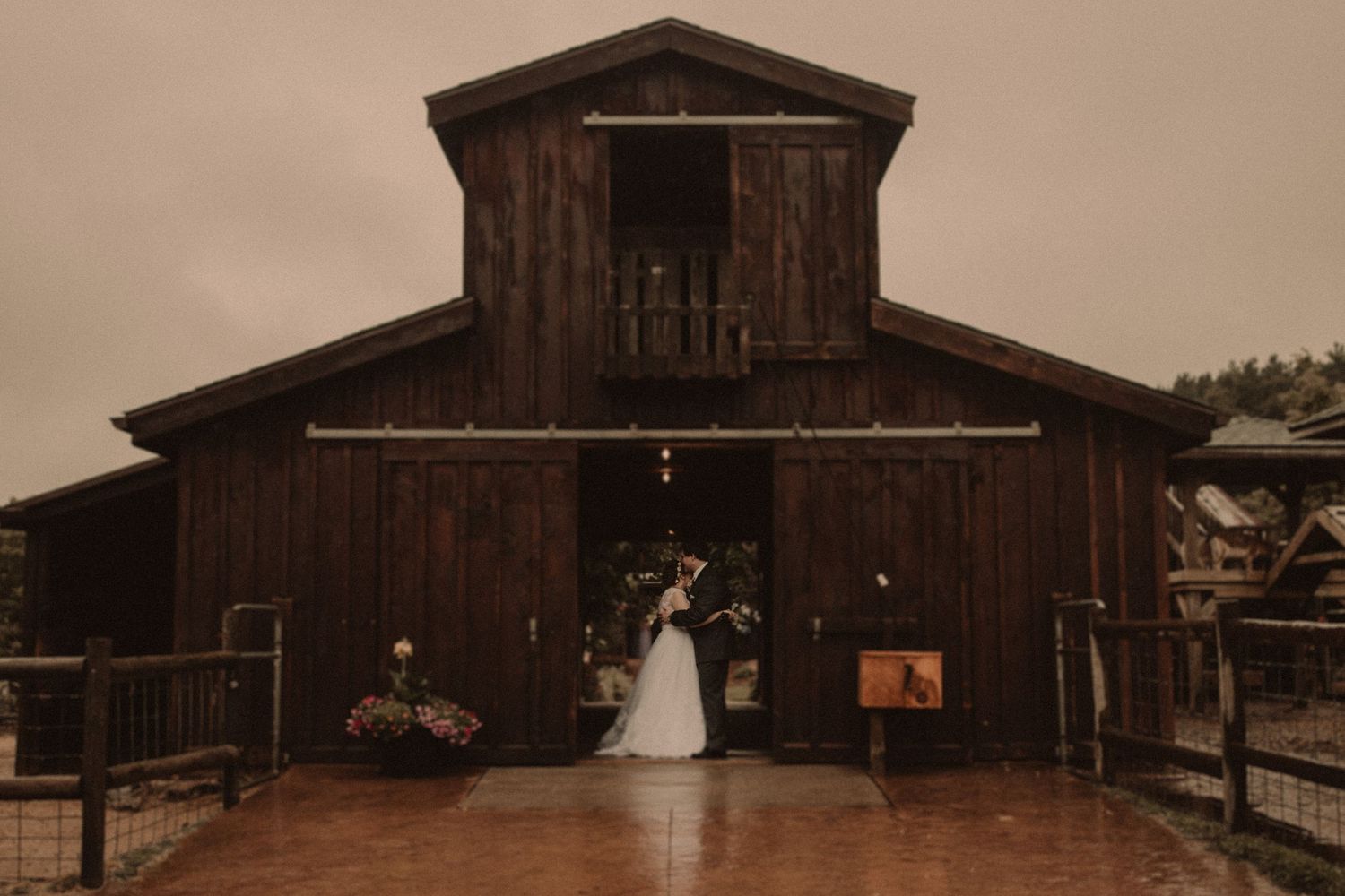 Wedding ceremony setup at rustic wooden barn entrance.