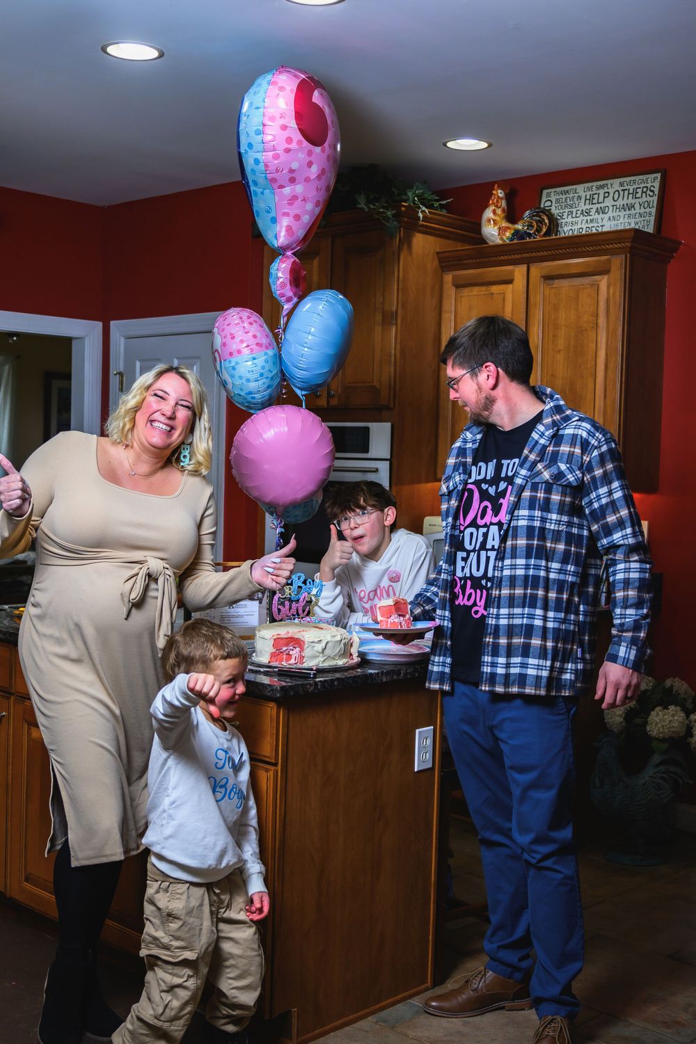 A celebration in a kitchen with colorful balloons, casual attire, and laughter around a counter space.