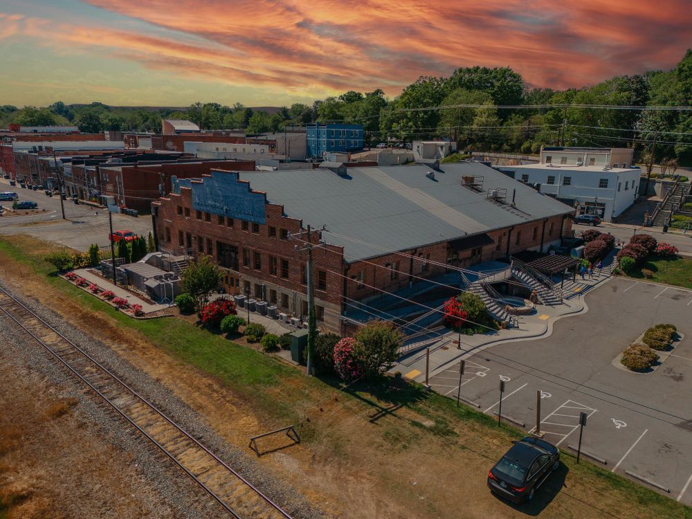 Downtown area with vintage brick buildings under a vivid sunset sky with industrial features.