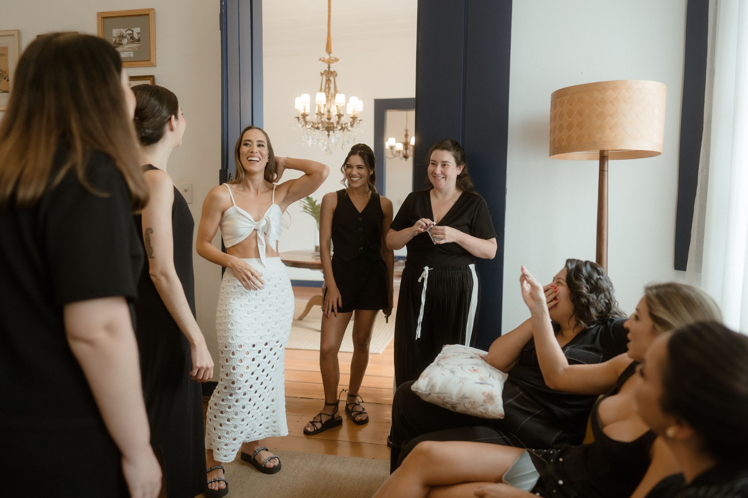 A bright interior space with white walls and natural lighting during a social gathering.