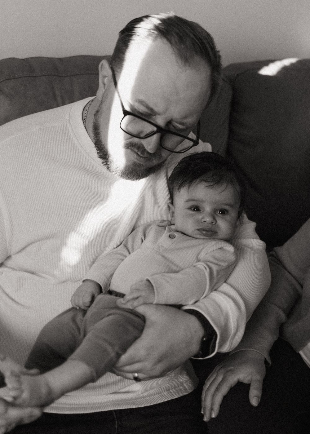 A tender black and white portrait of gentle bonding moments shared between a parent and infant.