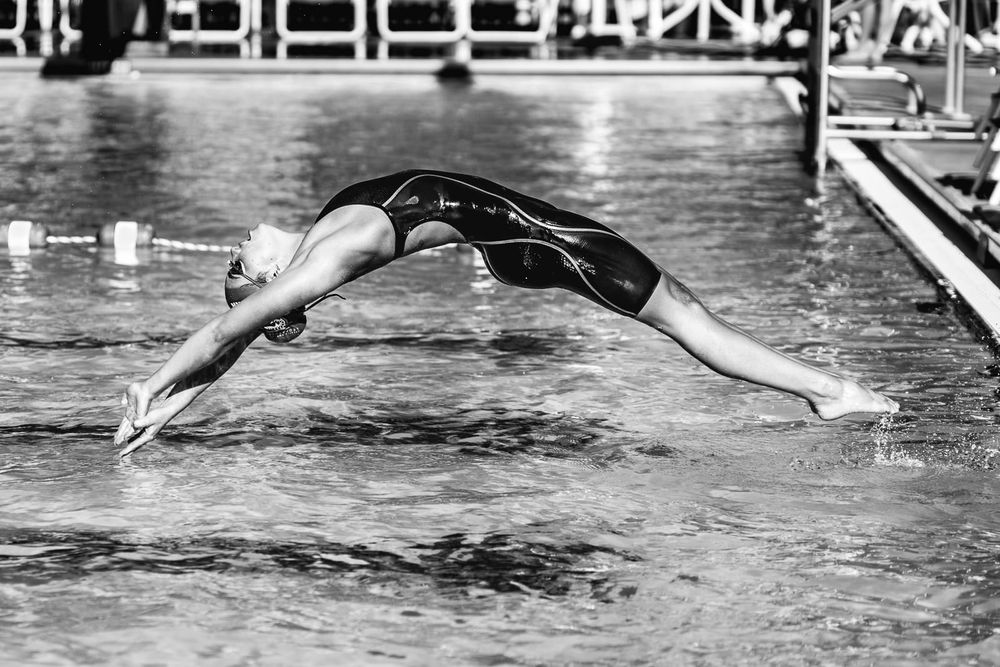 female swimmer performs backdive