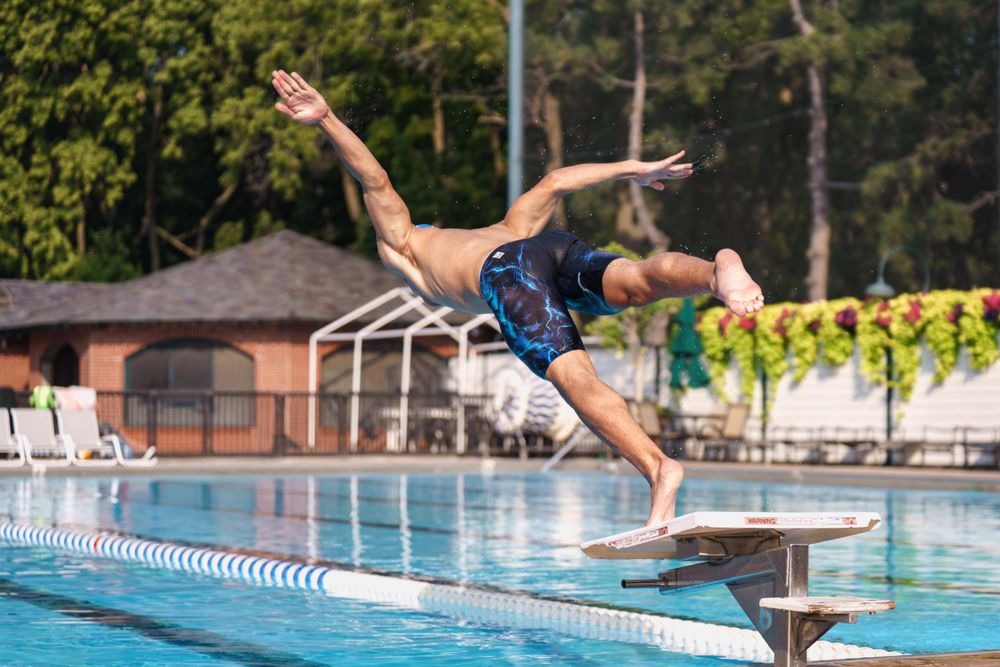 male swimmer dives into pool