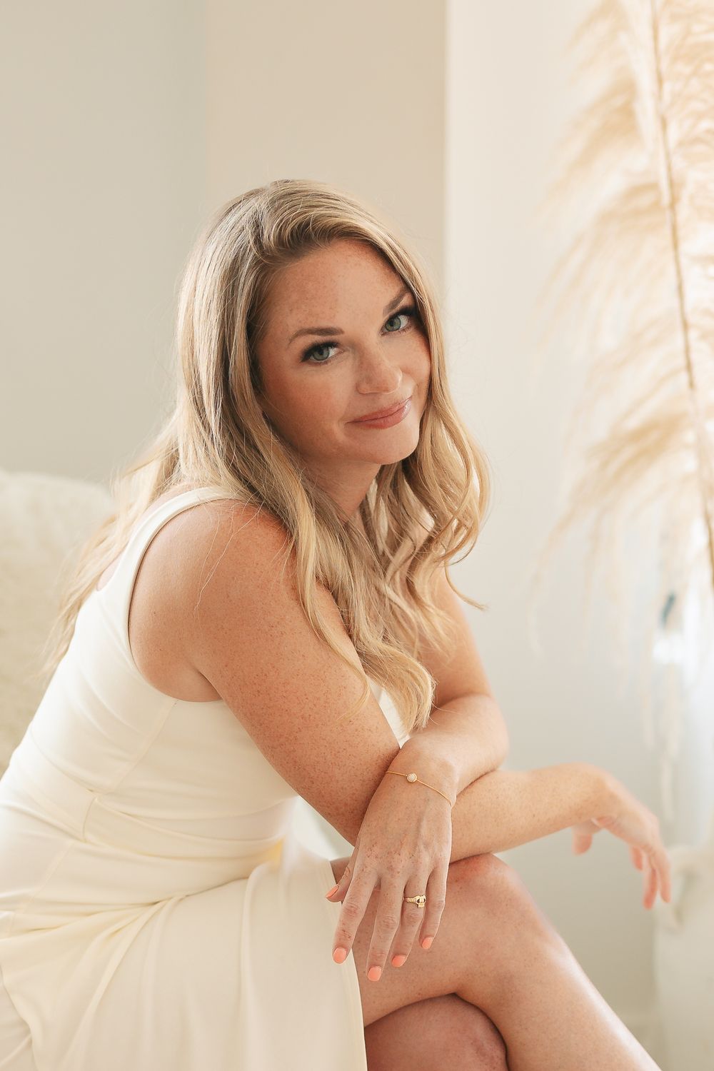 Soft natural light portrait in cream dress with decorative elements.
