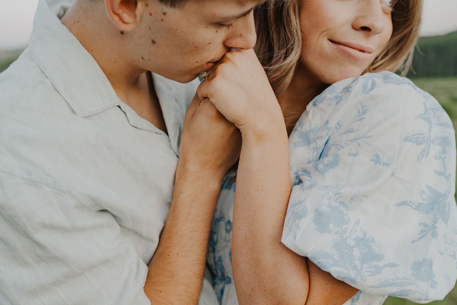 Intimate close-up of couple sharing tender moment outdoors.