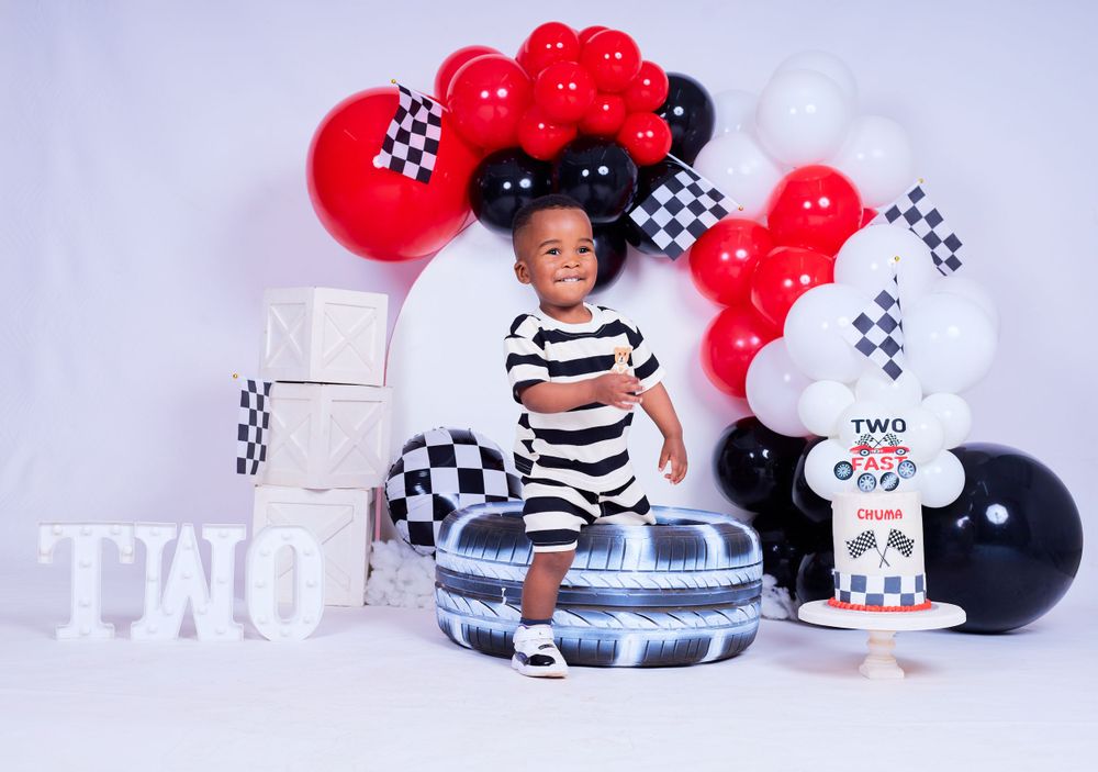 Racing themed party setup with red and black checkered balloons and decorative elements.