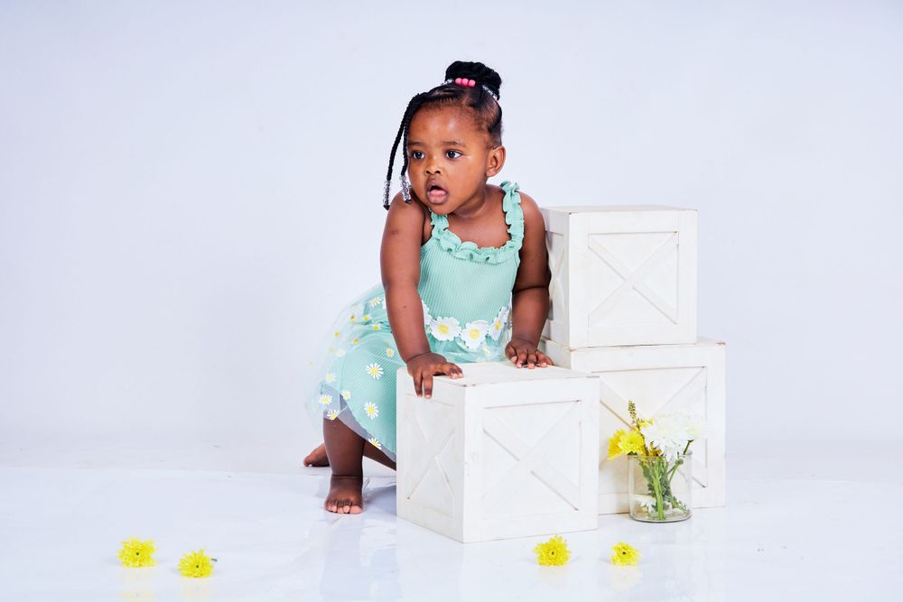 Professional studio photography setup with white backdrop and yellow floral decorations.