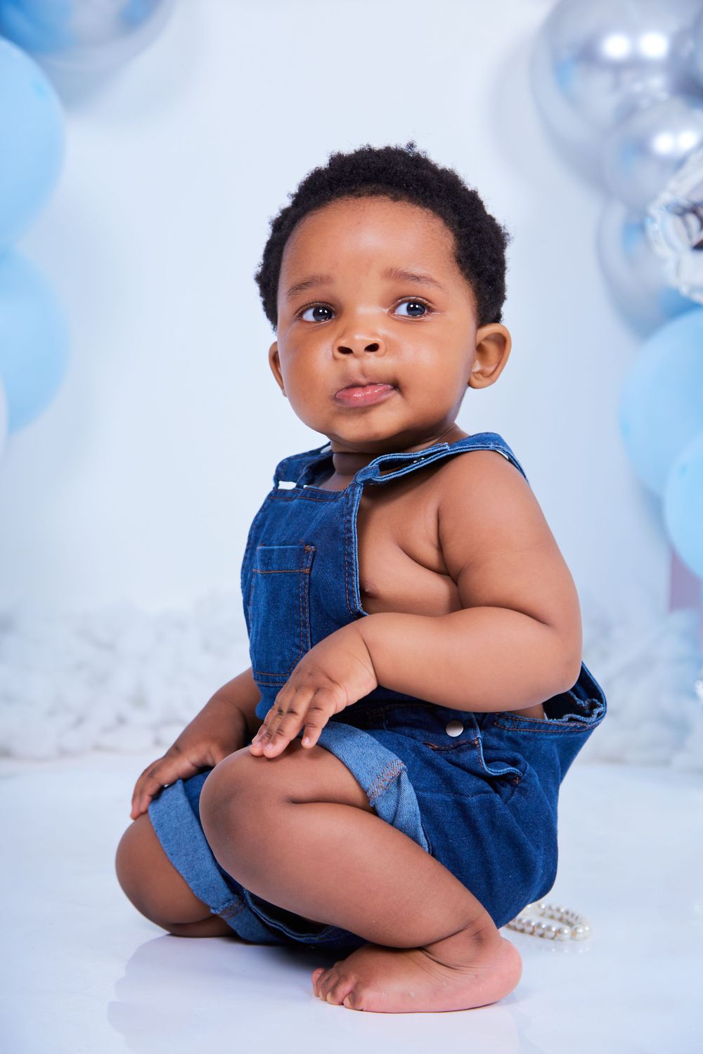 Studio setup with blue and silver balloon decorations against white backdrop.