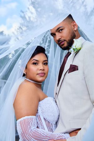 Romantic wedding portrait with bride in beaded gown and groom in light suit.