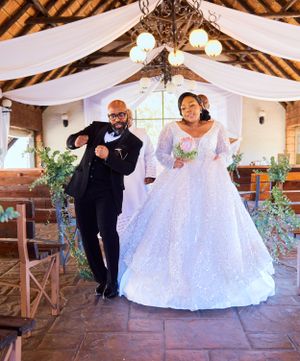 Wedding celebration in rustic venue with draped white fabric decor.