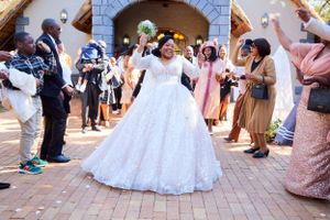 Wedding party dancing and celebrating on outdoor brick patio.