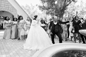 Joyful wedding celebration with guests dancing outdoors.