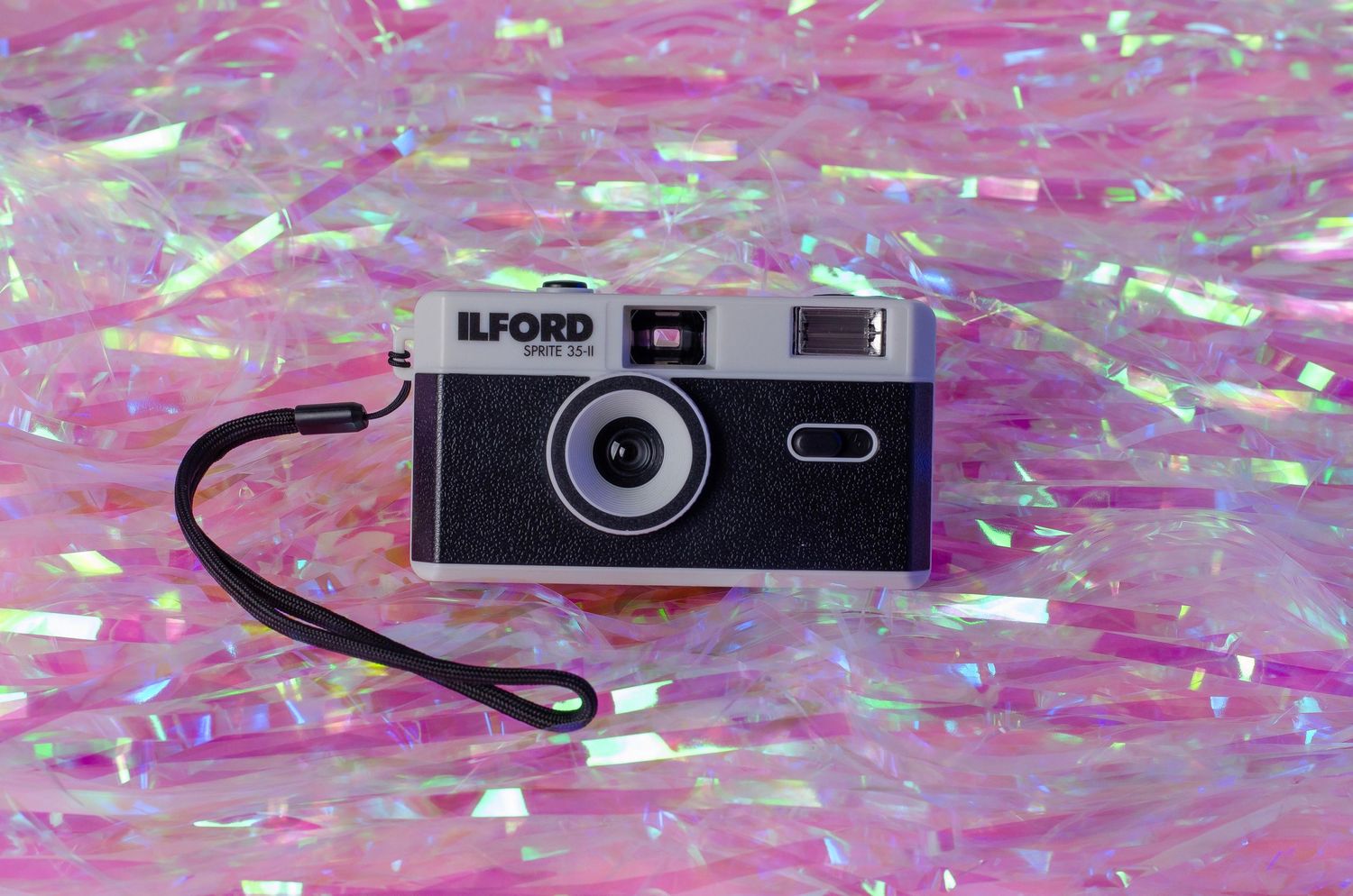An Ilford film camera displayed on pink iridescent background.