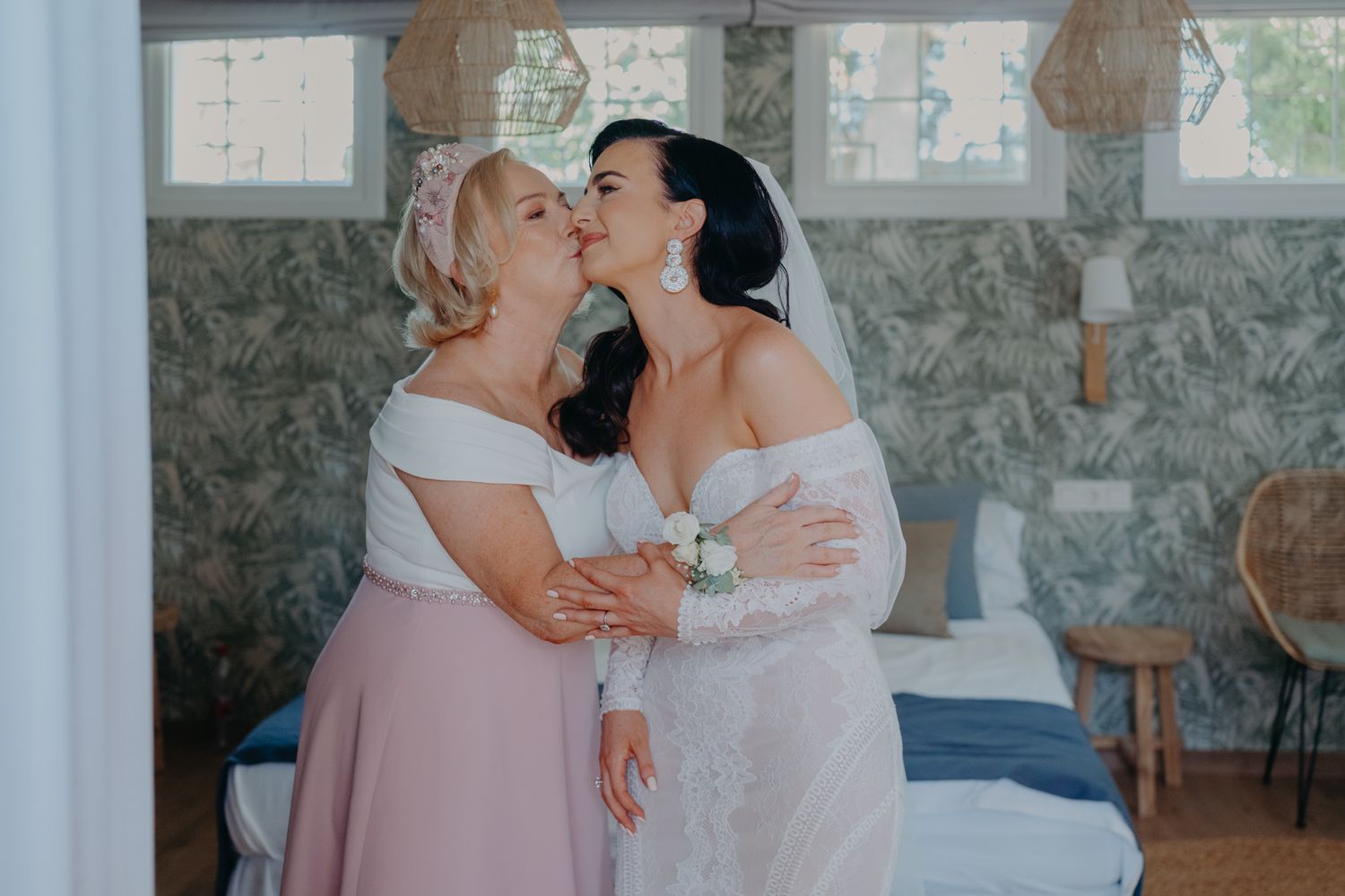 Two people share an emotional embrace while wearing formal attire in an indoor setting with stone walls.