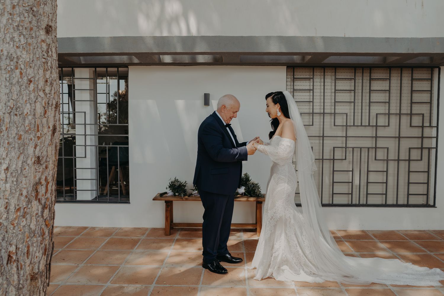 An emotional moment shared between a bride and older gentleman during a wedding ceremony.