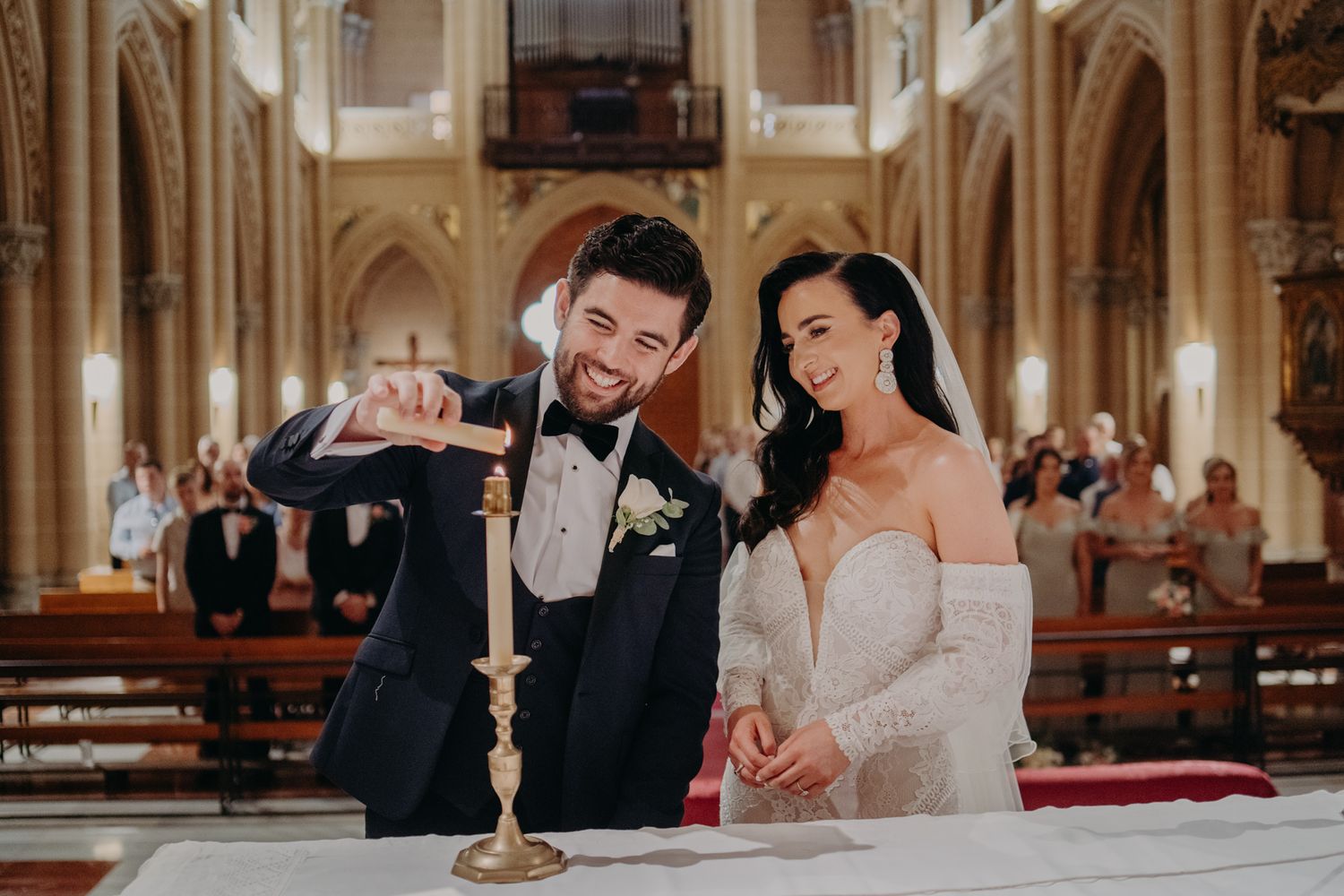 A couple lights a unity candle during their church wedding ceremony.