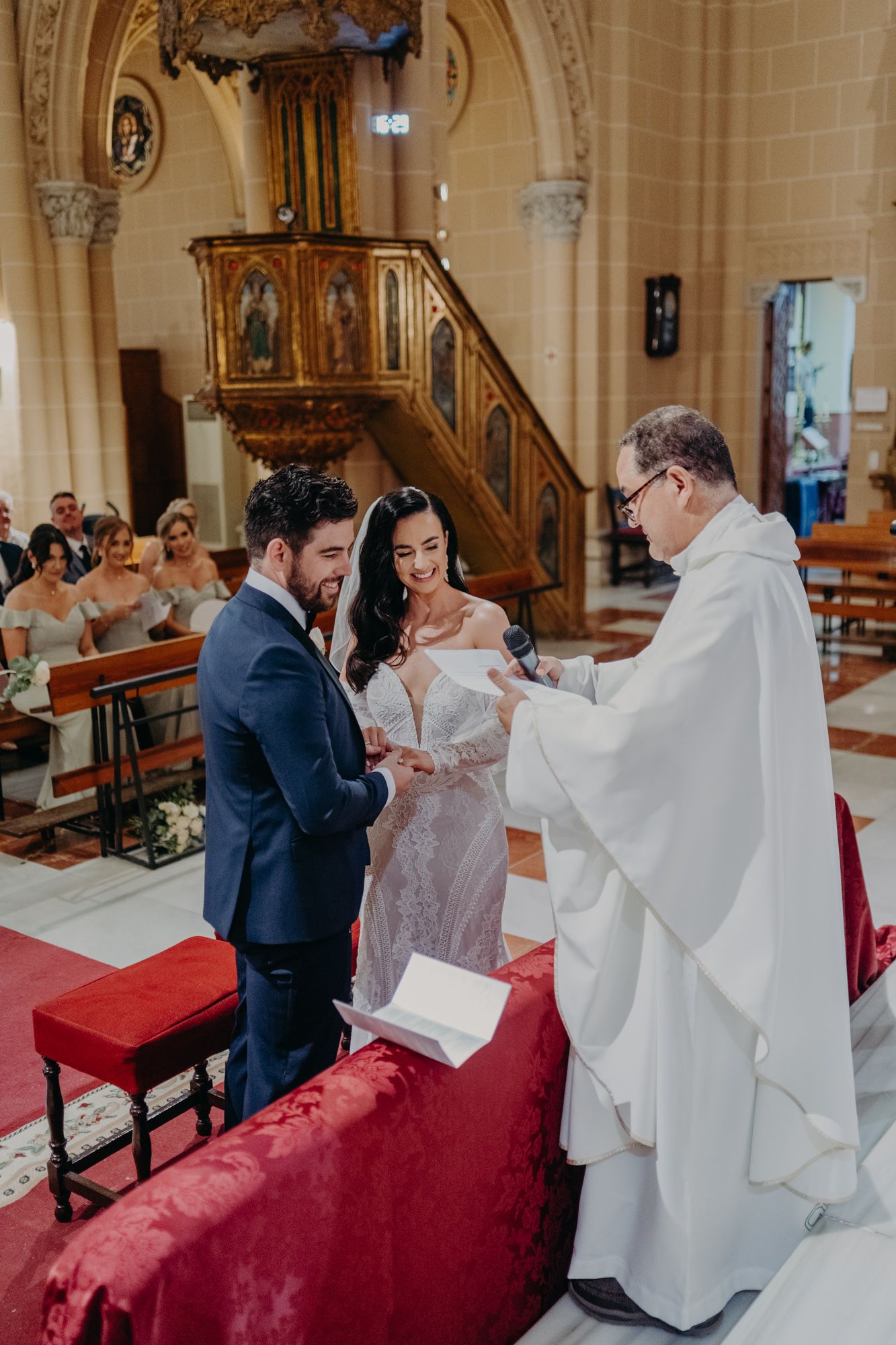 Traditional church wedding ceremony with priest performing marriage rites at ornate altar.