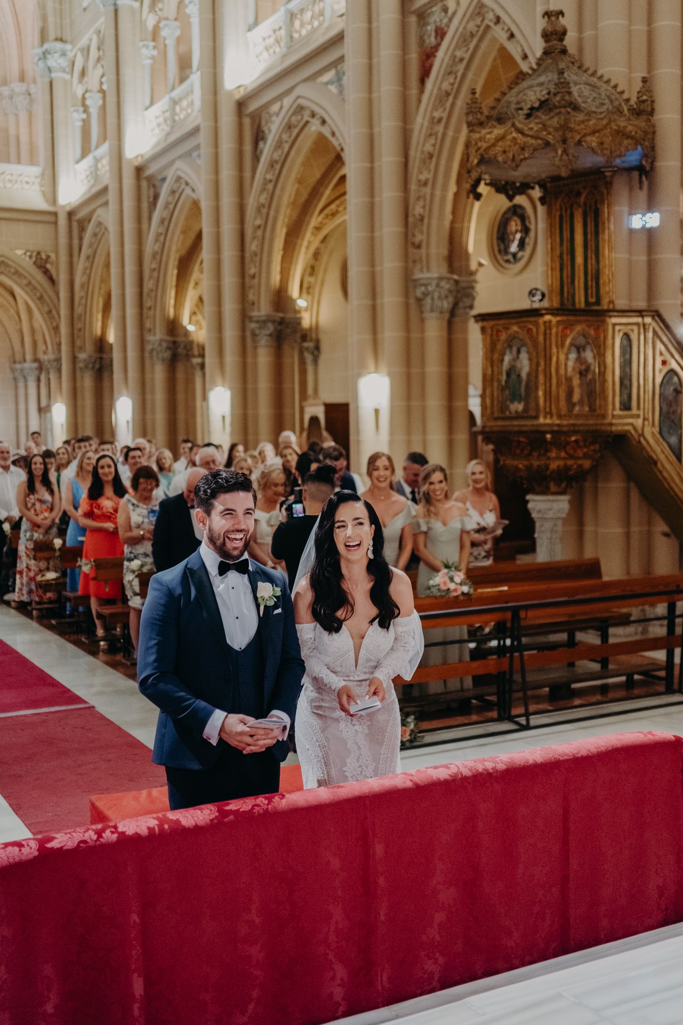 Interior of an elegant cathedral with ornate architecture showing a ceremony at the altar.