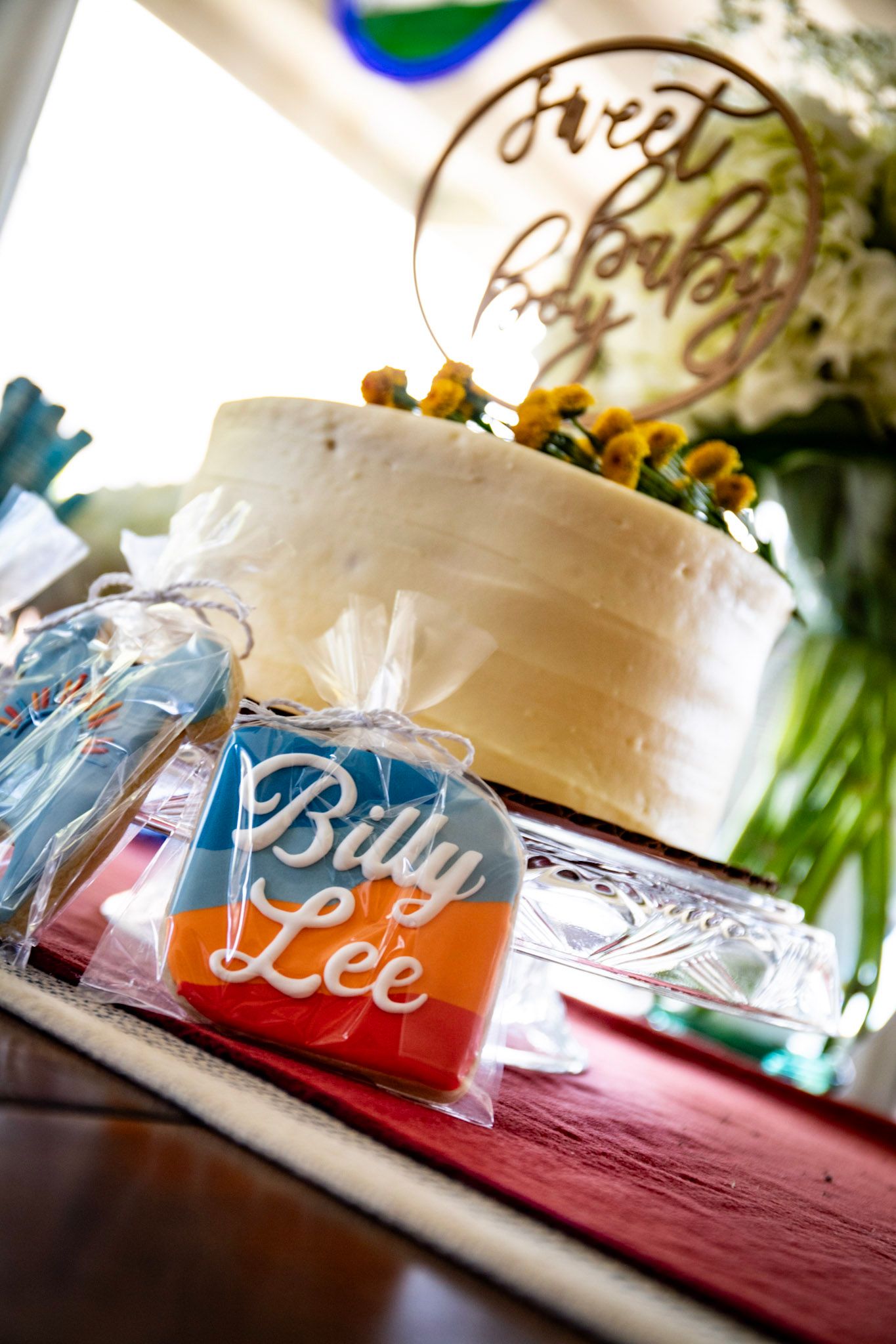 White wedding cake and personalized drink container labeled 'Billy Lee' on display.