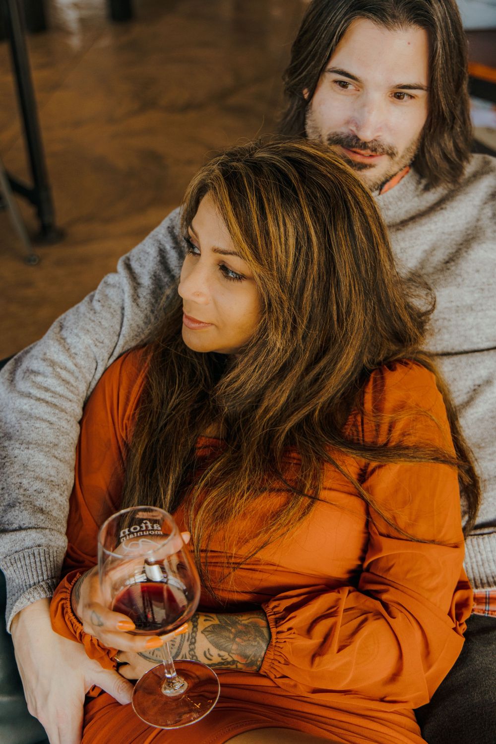 Romantic engagement session with wine glasses and mountain views at a Charlottesville winery.