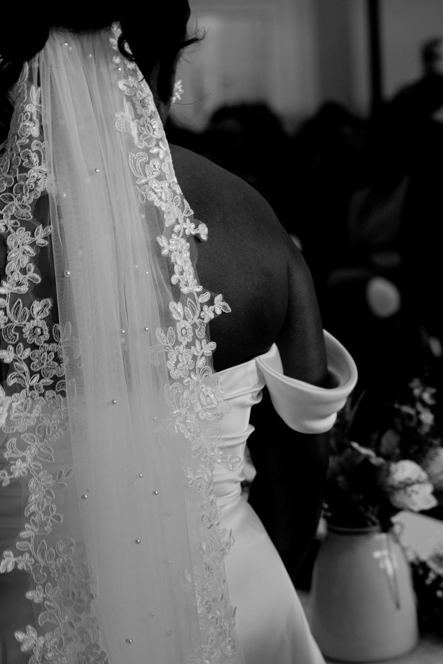Elegant lace wedding veil with delicate beading details shown in black and white.