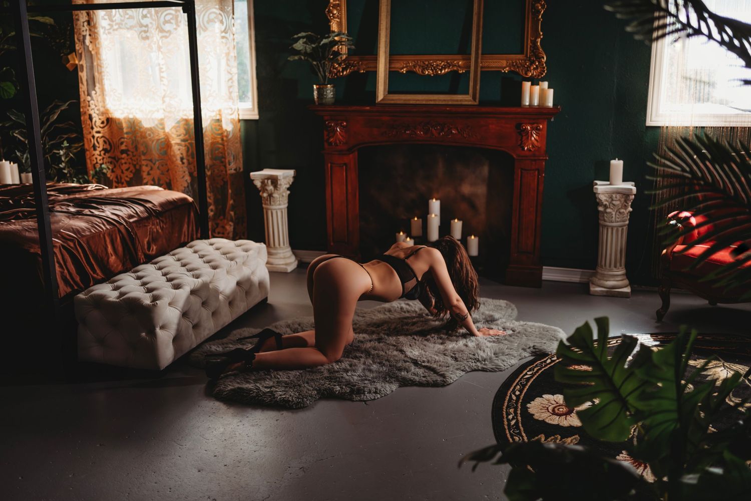 Someone in workout clothing exercising on a rug in a cozy living room with dark teal walls and a fireplace.