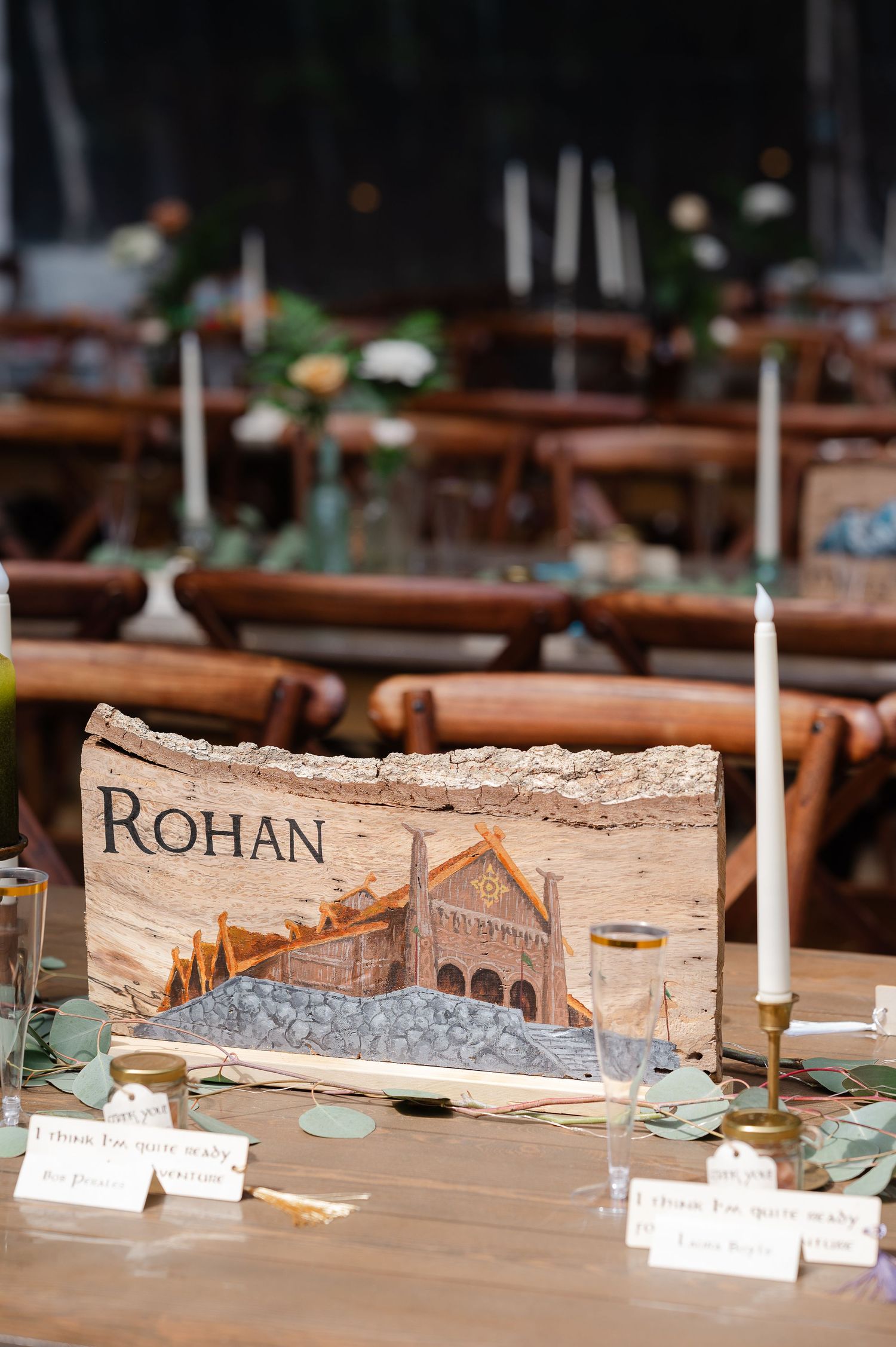 A white dragon figurine rests beside a rustic wood slice decorated with Erebor artwork from Lord of the Rings.