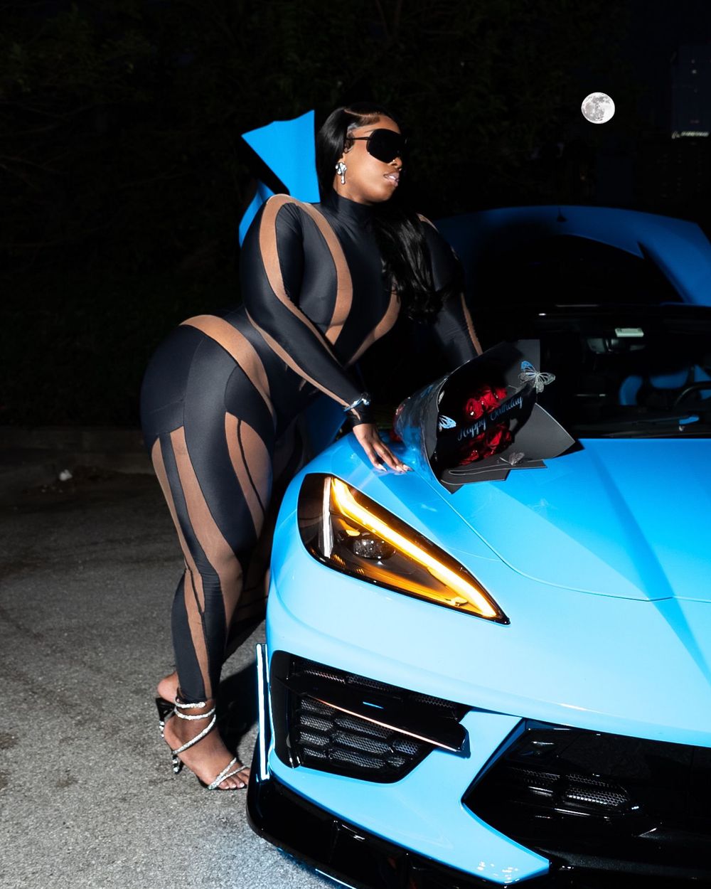Blue sports car with sleek design shown in a series of closeup detail shots at night.