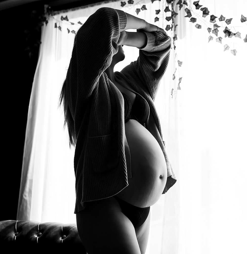 expecting mom plays with her hair by Wisconsin boudoir photographer