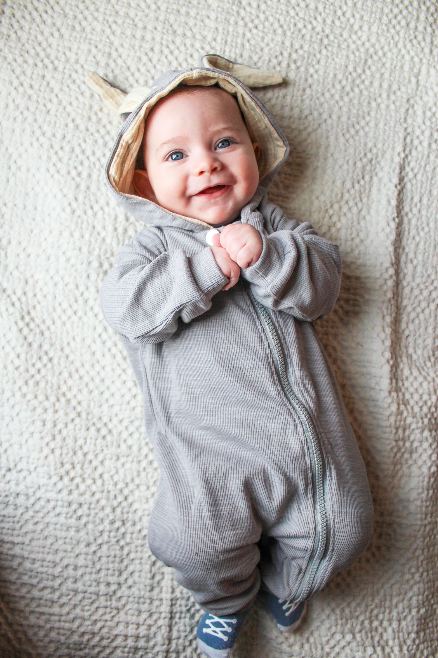 Springfield, IL family photographer captures baby laying down and smiling in a bunny onesie for easter photos