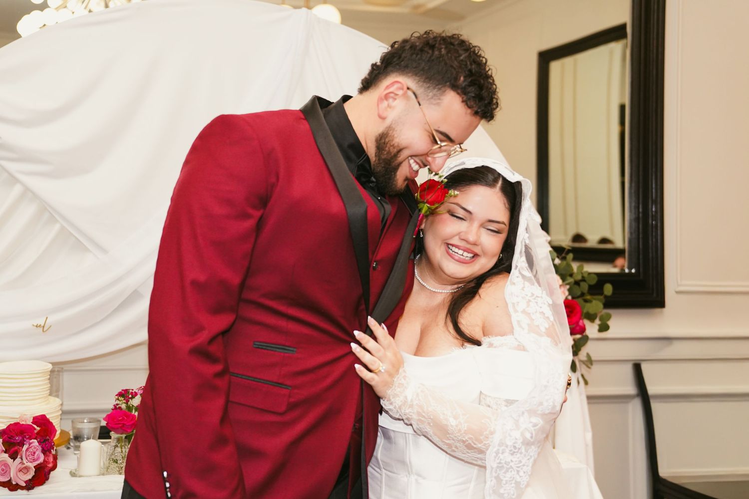 Couple celebrating during outdoor wedding ceremony under wooden arch.