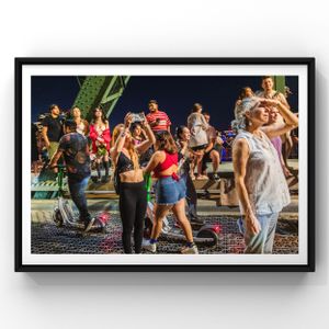 Dance fitness class participants exercising together outdoors at night with energetic movements and colorful lighting.