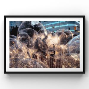Artistic photograph showing illuminated soap bubbles floating in front of urban architecture at twilight.