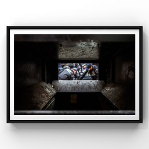 Urban art graffiti depicting figures in blue and gray tones viewed through a dark concrete frame.