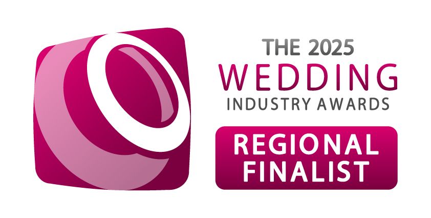 A pink and burgundy logo badge for The 2025 Wedding Industry Awards Regional Finalist with a curved abstract design.