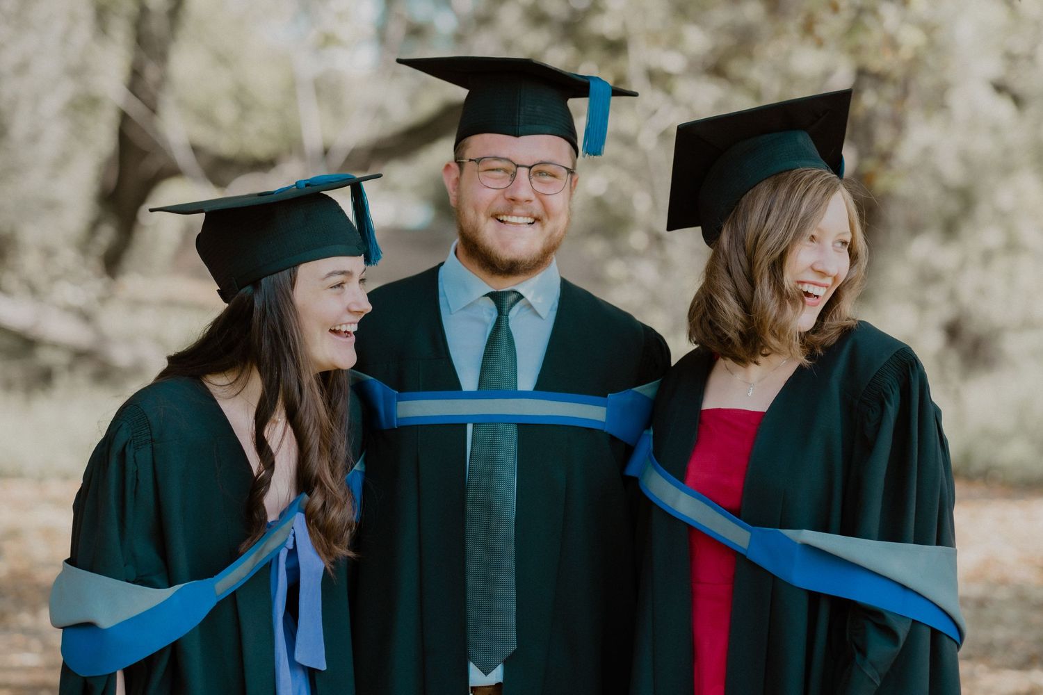 A cheerful group of graduates in caps and gowns celebrating their achievement.