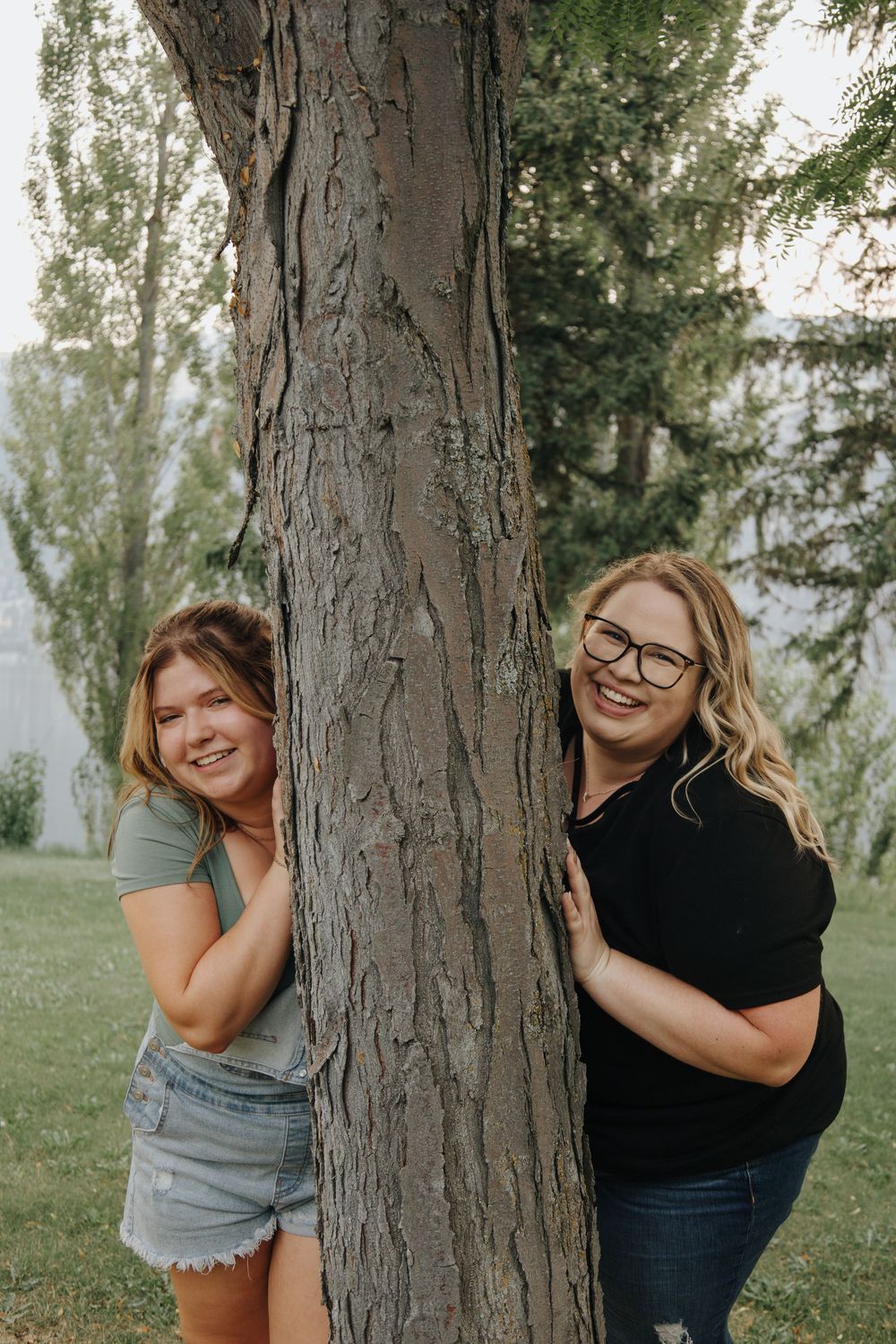 Playful portraits of people peeking around tree trunks in an outdoor setting.