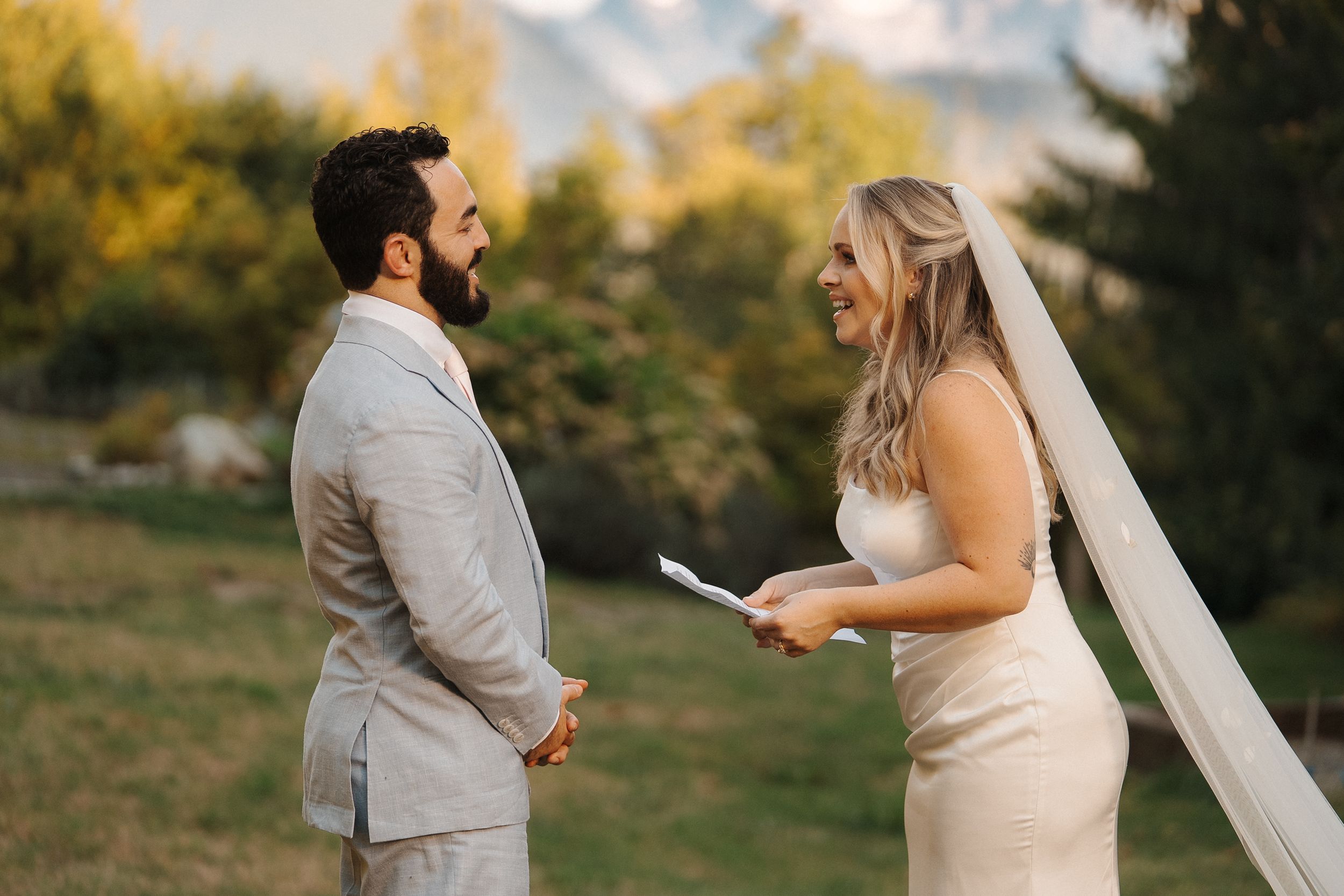 A happy couple shares a joyful moment during their outdoor autumn wedding photoshoot.