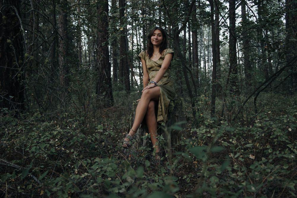 Moody woodland photography series with figure posed against dense forest backdrop.