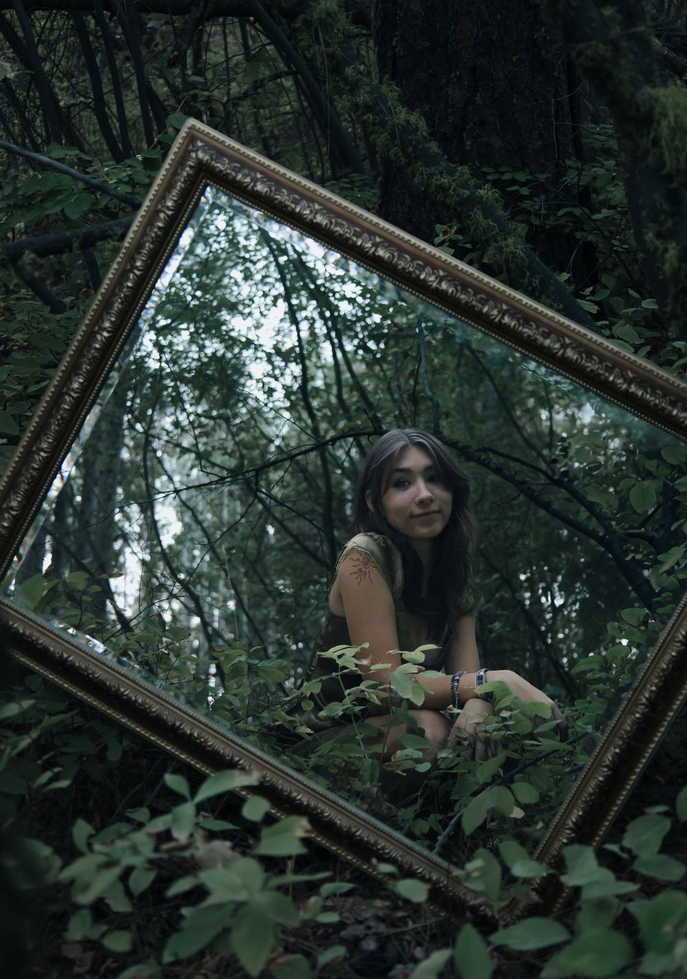 Creative portrait series using an ornate mirror frame in a mystical forest setting.