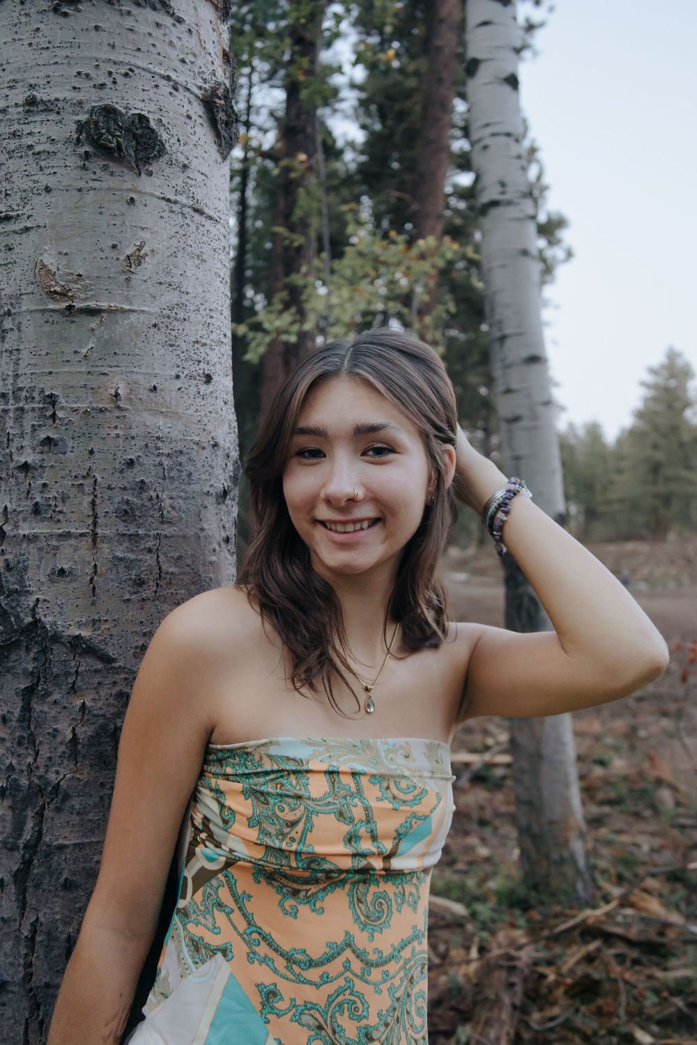 Portrait series against birch tree bark showing person in patterned top.