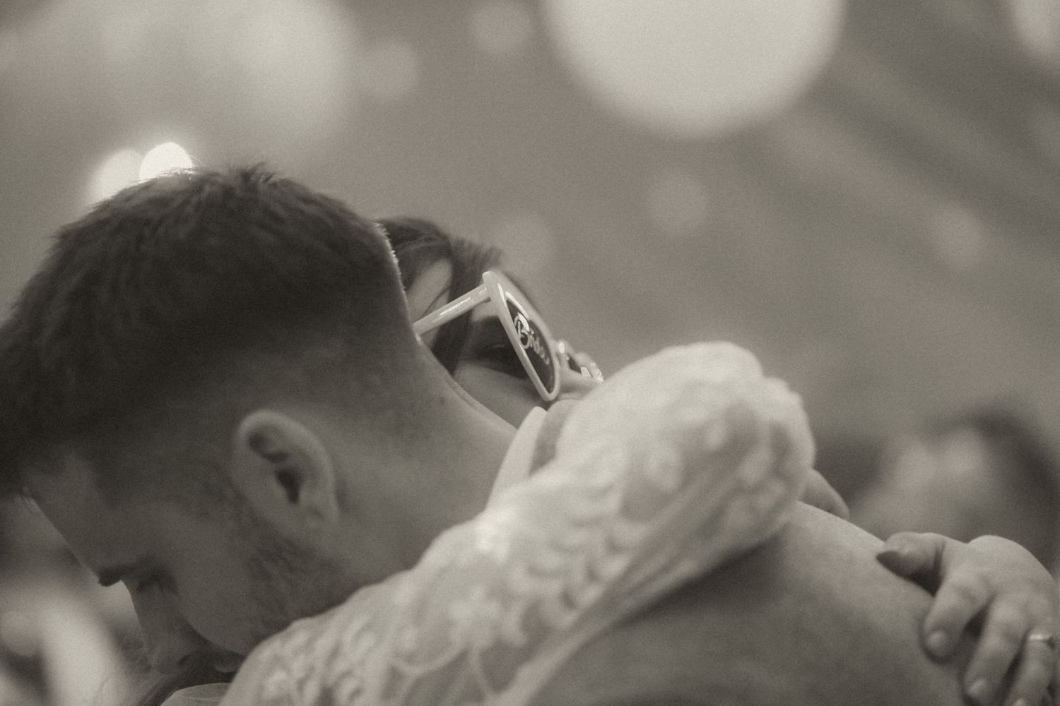 A series of candid black and white photos showing intimately cropped moments between couples during wedding celebrations.