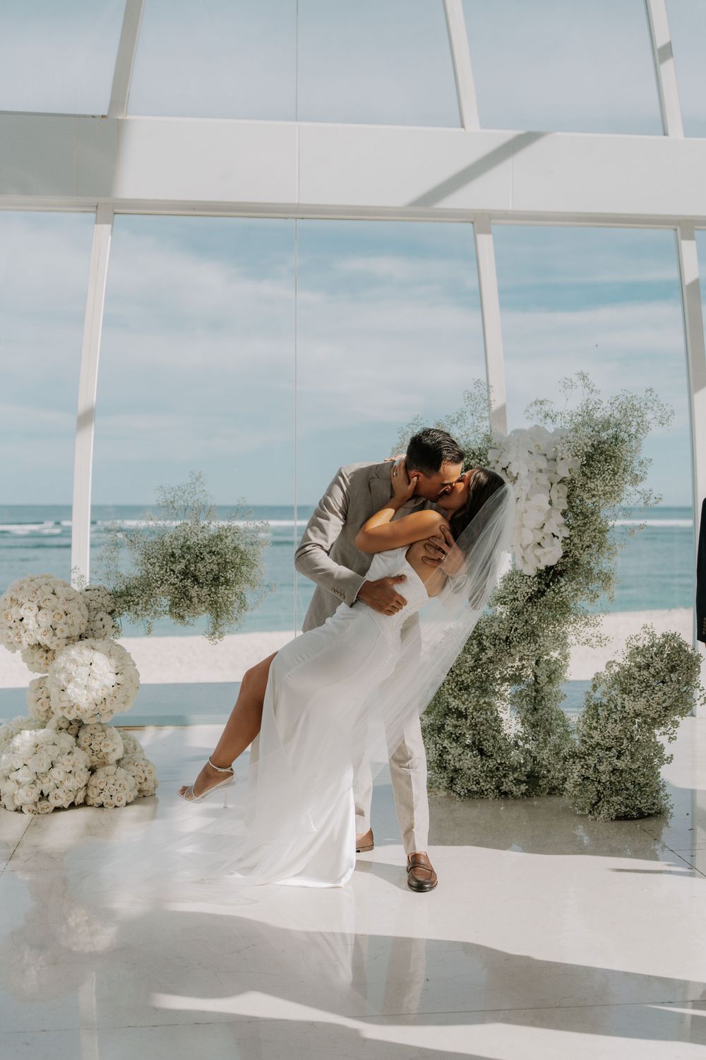 A sequence of artistic photos showing ethereal movement with flowing white fabric in a bright, oceanside studio space.