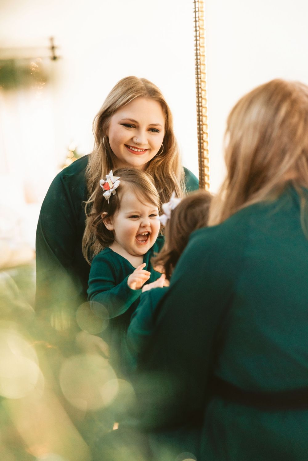 Candid moments of joyful laughter between parent and child during holiday photo session.