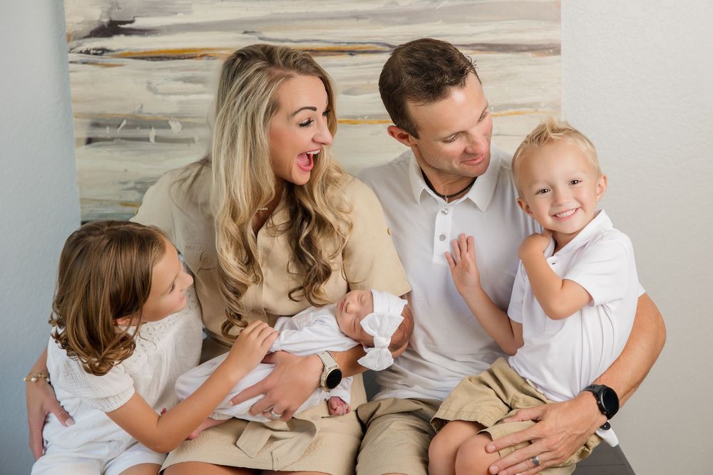 A family shares happy moments together while lounging on a white sofa at home.