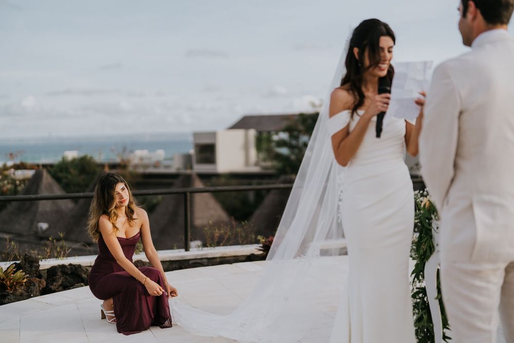Elegant outdoor wedding ceremony with white decor and floral arrangements.