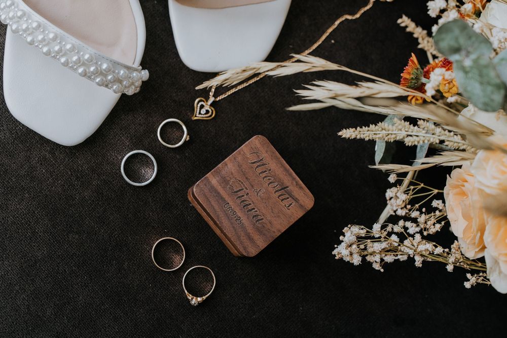 Wedding details including rings and decorative elements on dark background.