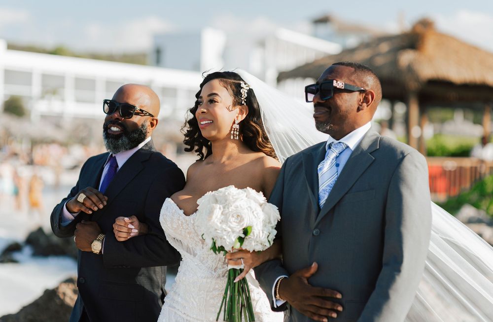 Wedding party members share joyful moments and embraces during an outdoor celebration.