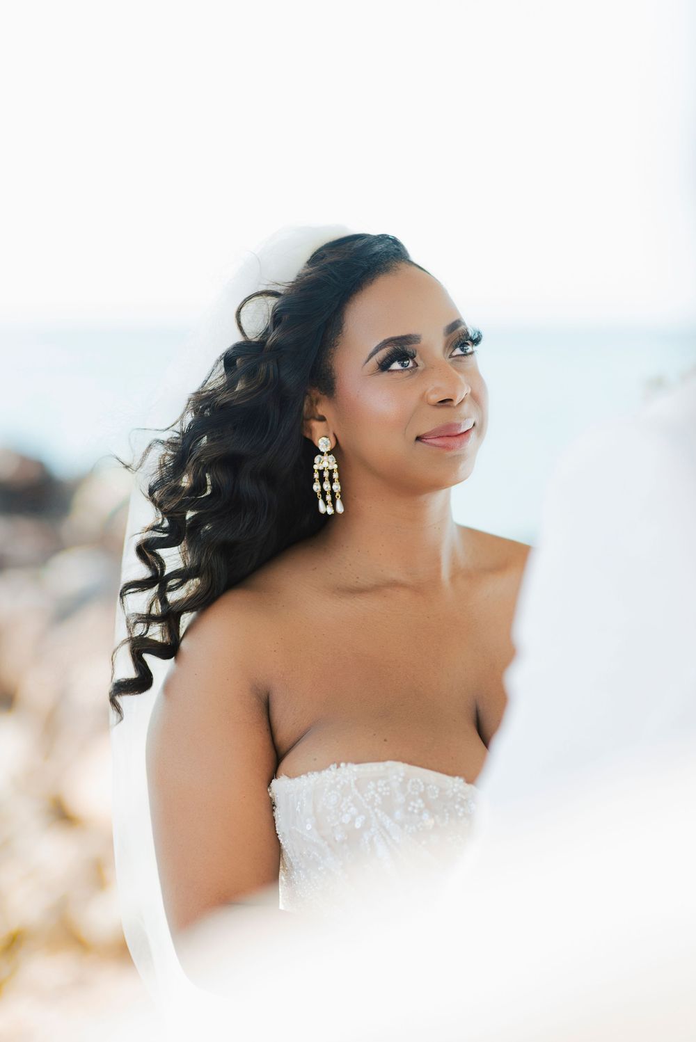 Artistic bridal portraits showing a woman in a white lace dress with flowing dark curls.
